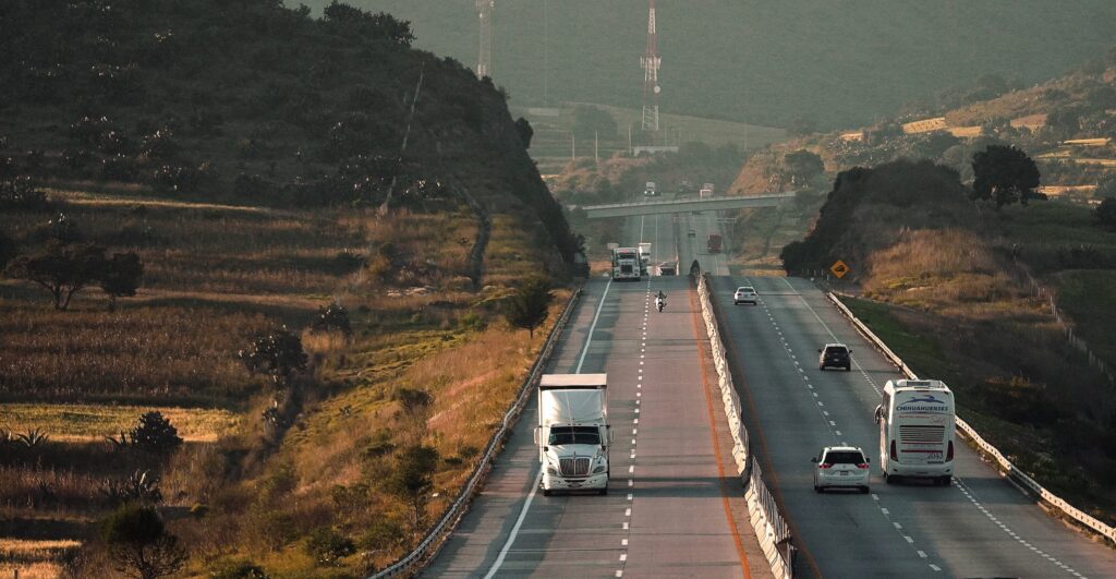 Image of several trucks on two roads with mountains in the background. Cargo insurance coverage is vital for anyone shipping with these trucks.