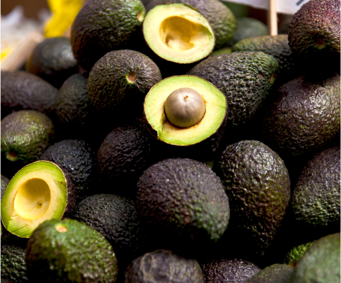 The image shows avocado transportation in action with a close-up of several avocados.