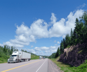 White truck with blue sky background on road.